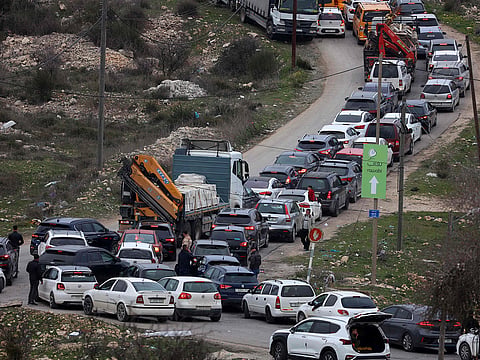 Commuters wait in their vehicles at the Israeli Atara checkpoint on route 465 near Ramallah in the occupied West Bank on January 22, 2025.  