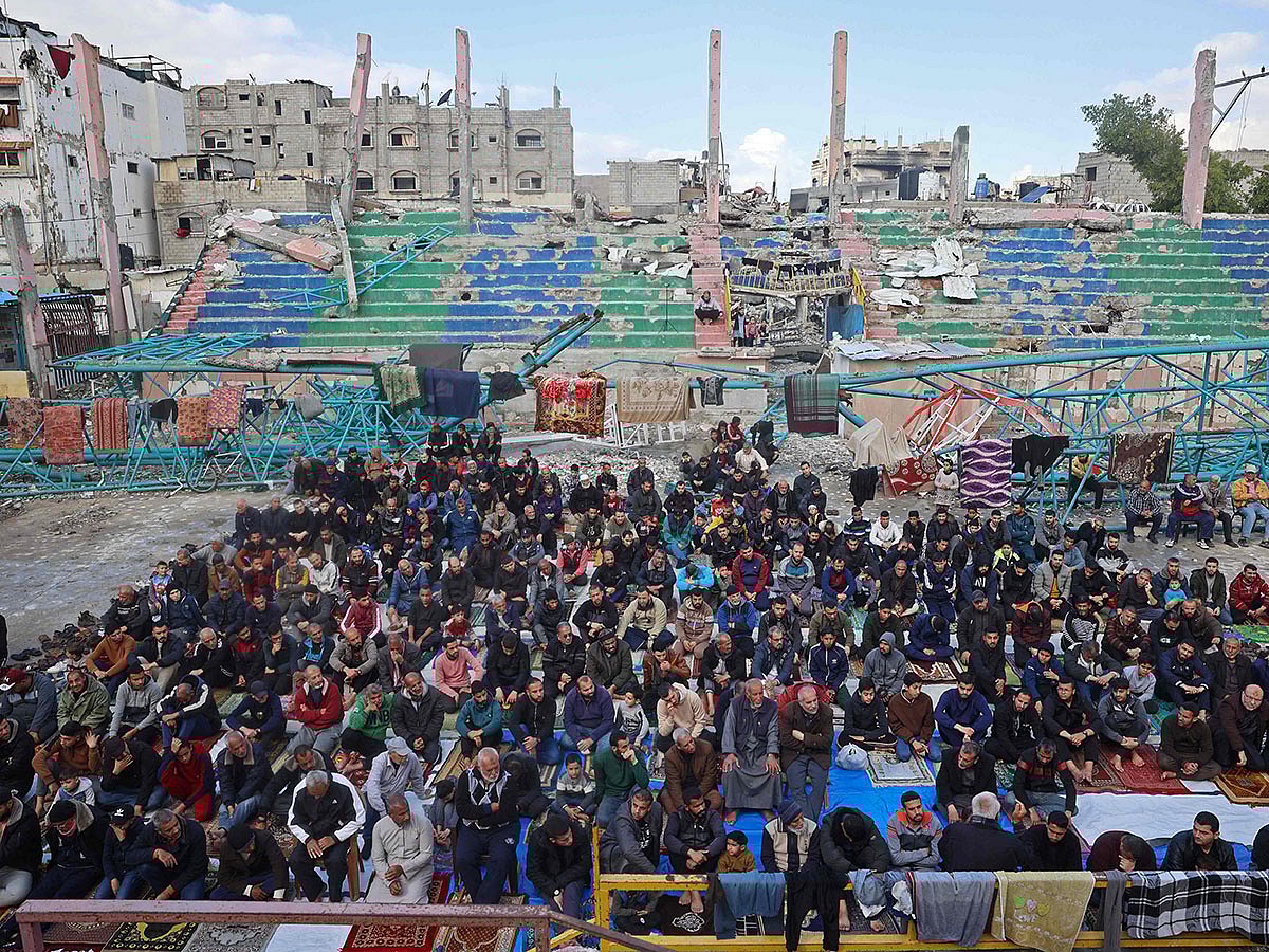 Devotees offer Friday prayers at a damaged open gymnasium in a camp for displaced Palestinians in Bureij, in the central Gaza Strip.