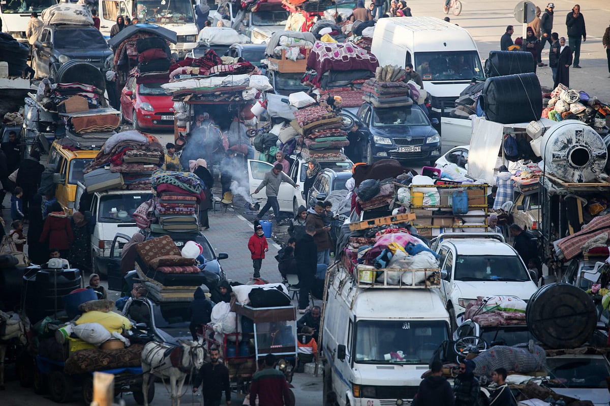 Displaced Palestinians wait along the Salah Al Din road in Nuseirat to cross to the northern part of the Gaza Strip on January 26, 2025.