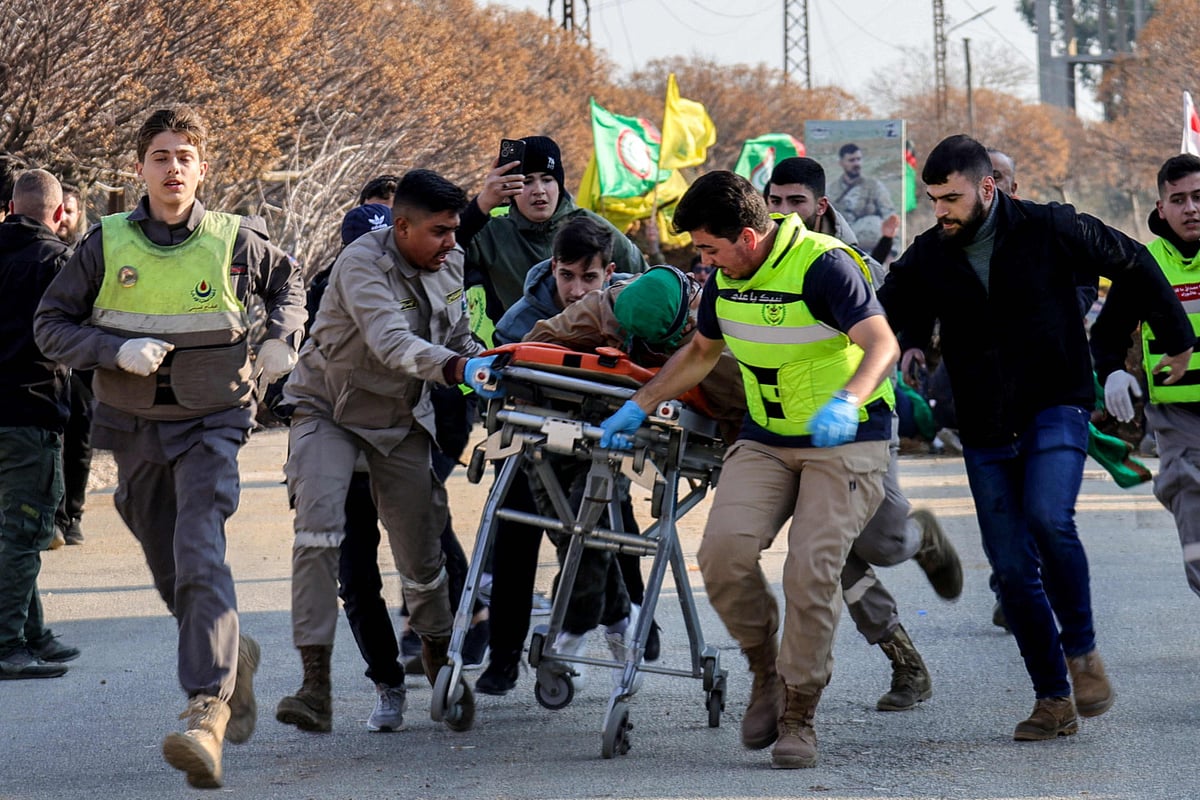 Lebanese paramedics rush a man who was reportedly shot by Israeli soldiers as he tried to make his way with other residents towards the southern Lebanese village of kfarkila, to an ambulance at a Lebanese army checkpoint in Burj Al Muluk on January 27, 2025.