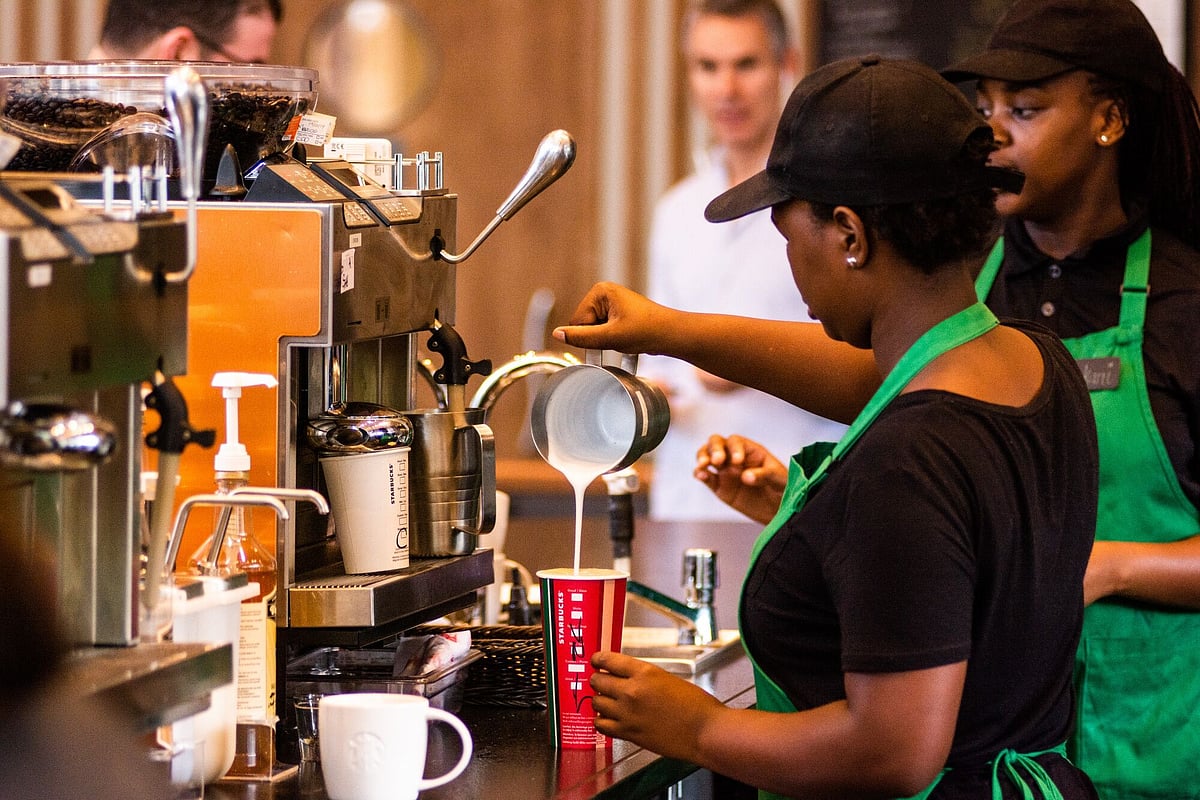 Baristas serving customers at Starbucks Corp. cafe.