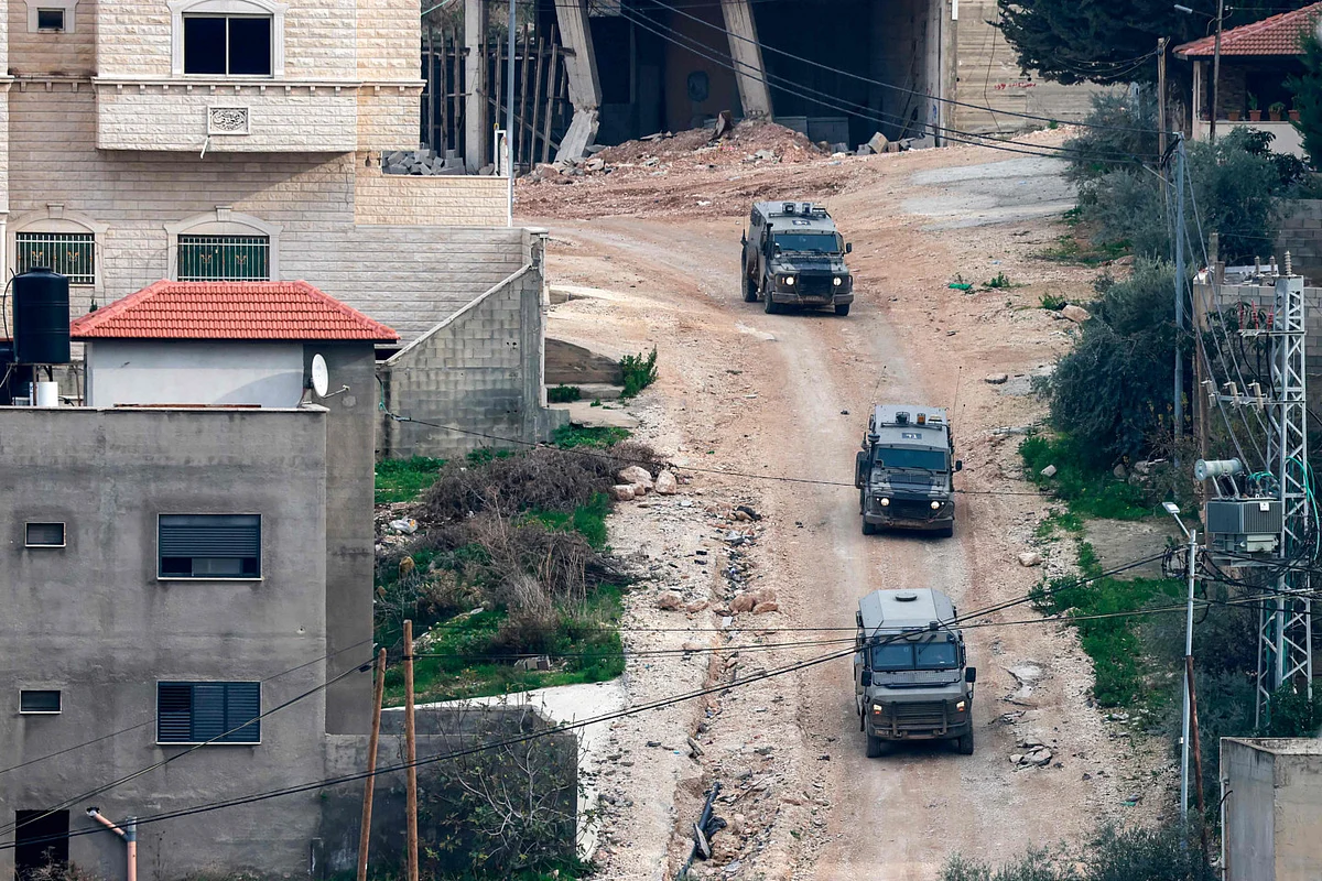 Israeli army armoured vehicles move along a road during a military operation in the Jenin camp for Palestinian refugees in the north of the occupied West Bank on February 3, 2025.  