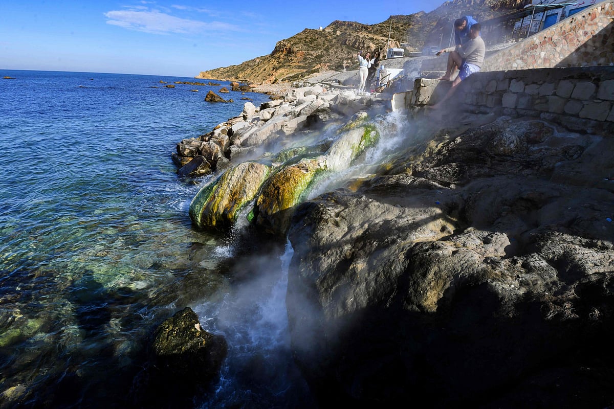 People visit Ain Atrous, a natural hot spring that flows into the sea in the thermal region of Korbous, in Tunisia.