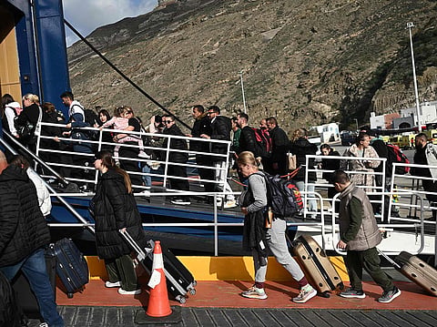 People embark a ferry at the port on the Greek Island of Santorini on February 3, 2025, to leave in the wake of recurring earthquakes.