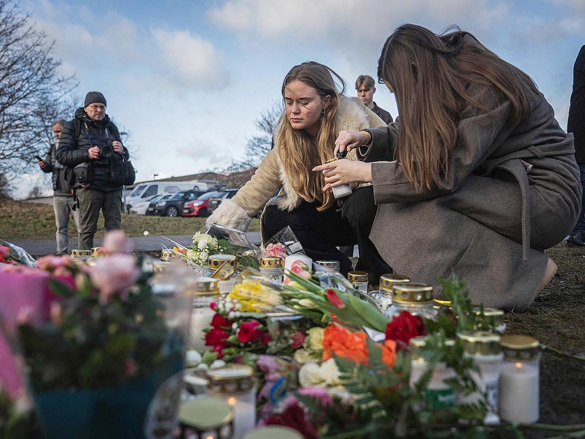 People light candles at a makeshift vigil near the adult education center Campus Risbergska school in Orebro, Sweden, on February 5, 2025 one day after a shooting there left eleven people dead. 