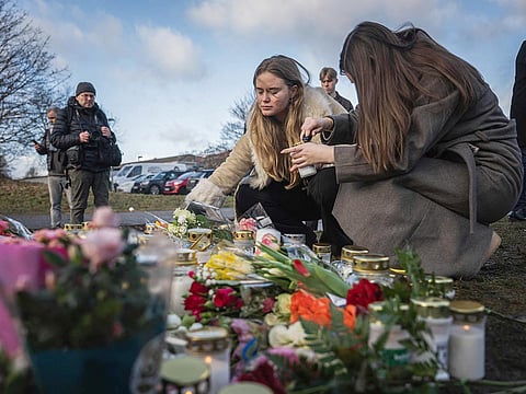People light candles at a makeshift vigil near the adult education center Campus Risbergska school in Orebro, Sweden, on February 5, 2025 one day after a shooting there left eleven people dead. 