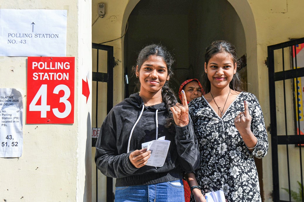 First-time voters show their fingers marked with indelible ink after casting their votes for the Delhi Assembly elections, at Lady Irwin School in New Delhi on Wednesday.  