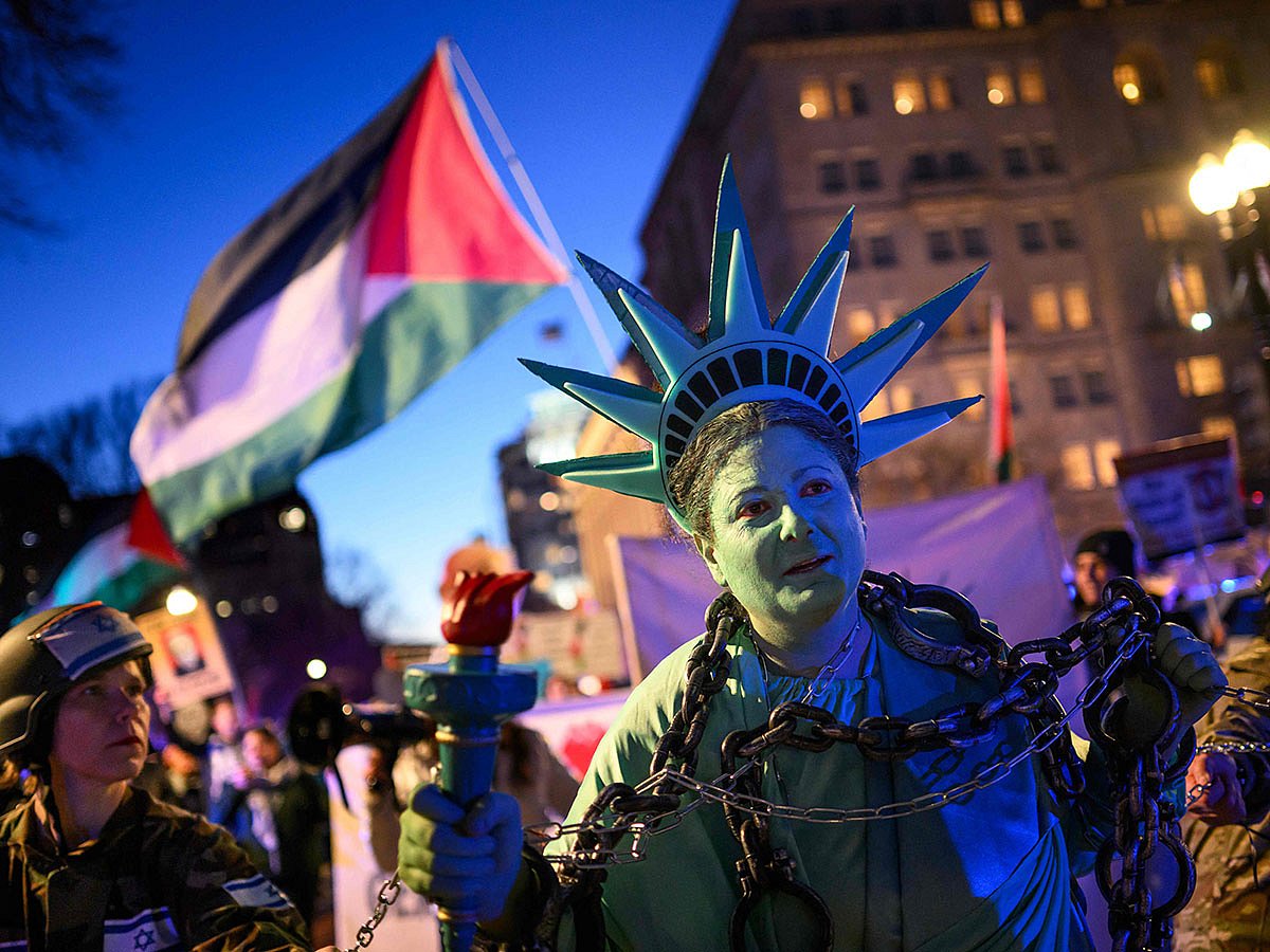 An activist dressed as the Statue of Liberty is pulled in shackles as they rally in support of Palestinians during the "Arrest Netanyahu at the White House Rally" near the White House in Washington, DC, on February 4, 2025.  