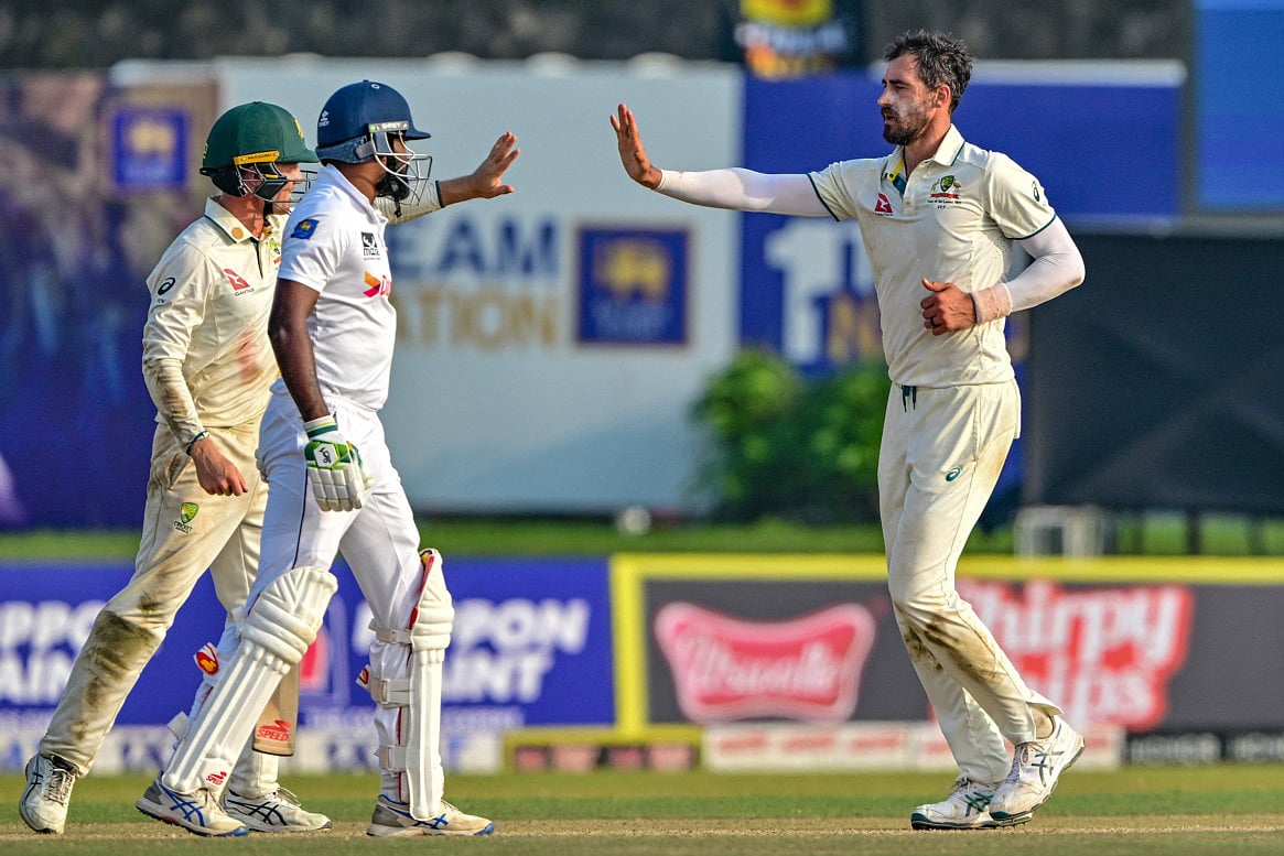 Australia's Mitchell Starc (right) celebrates with teammates after taking the wicket of Sri Lanka's Prabath Jayasuriya during the first day of the second Test cricket match at the Galle International Cricket Stadium in Galle on Thursday.