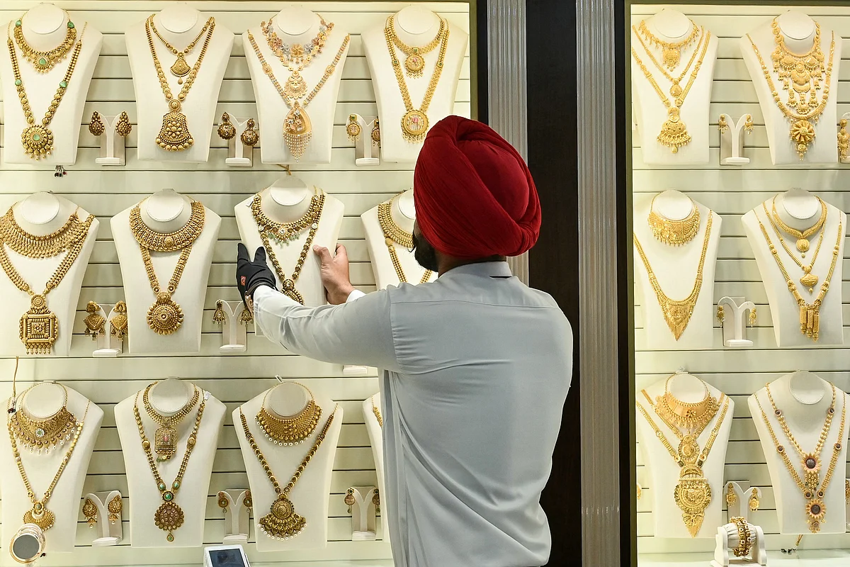 An employee arranges gold jewellery kept for display.