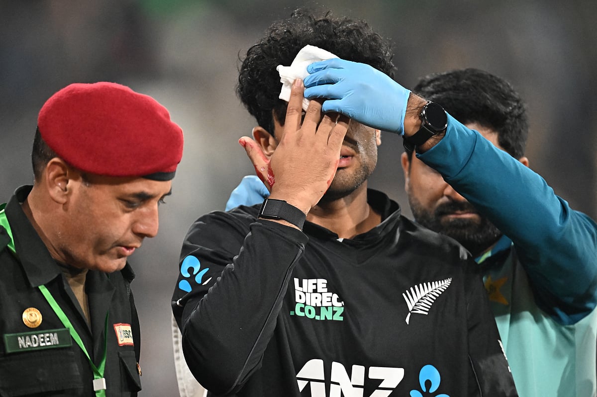 New Zealand's Rachin Ravindra (C) receives medical attention after being hit on the head by the ball during the Tri-Nation's first one-day international cricket match between Pakistan and New Zealand at the Gaddafi Stadium in Lahore on February 8, 2025.