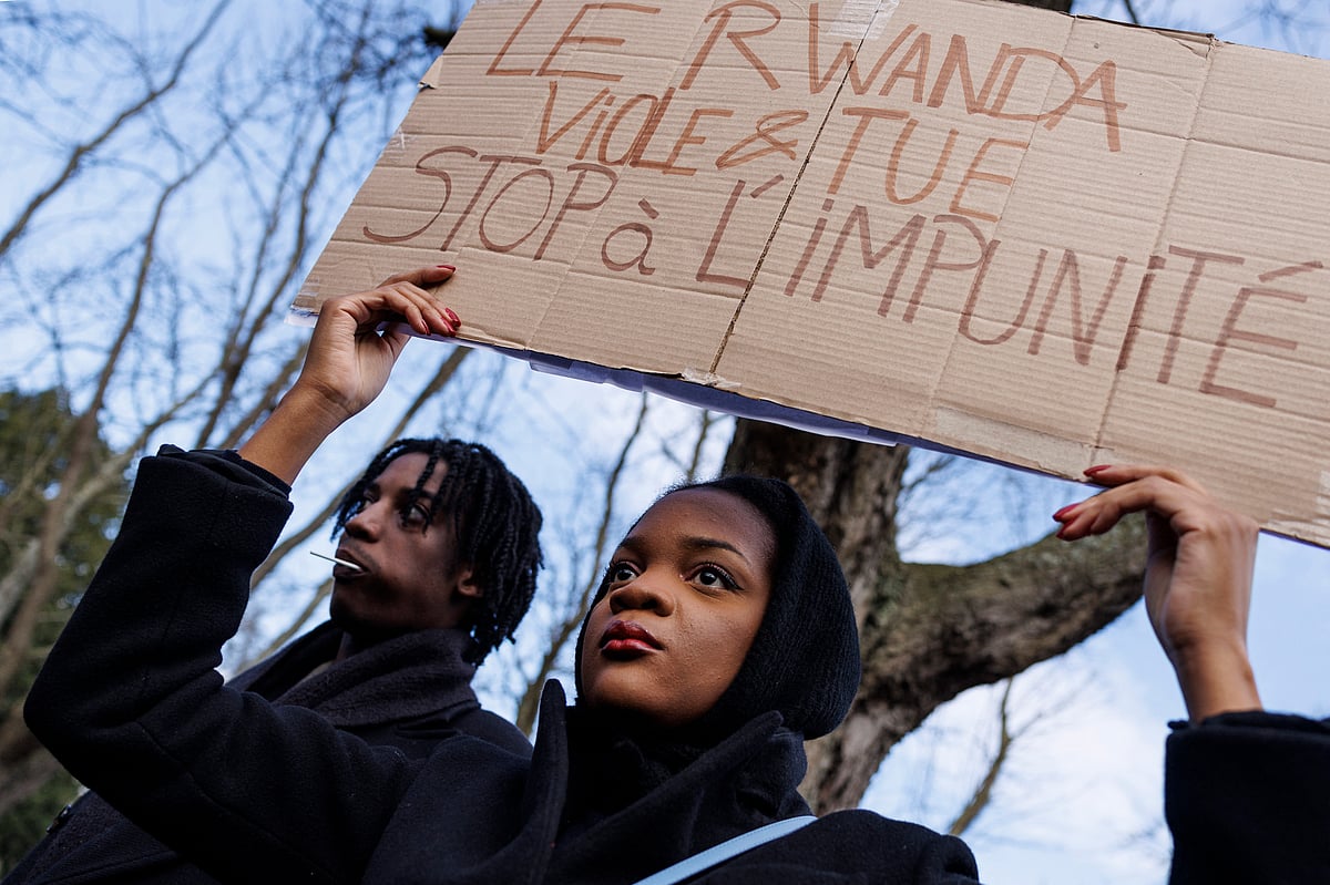 A demonstrator holds a slogan which reads in French "Rwanda rapes and kills, Stop impunity" during a protest in front of the Embassy of Rwanda in Brussels, on February 8, 2025, against Rwandan-backed armed group M23 offensives in eastern DR Congo that has left thousands dead and displaced.