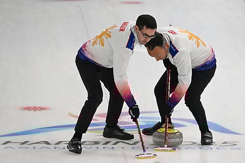 Philippines' Christian Haller (L) and Alan Frei sweep during the men’s curling round robin group A session 5 between the Philippines and Kazakhstan during the Harbin 2025 Asian Winter Games in Harbin.
