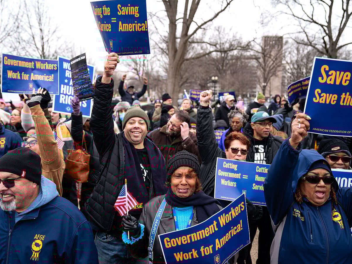 People hold signs as they gather for a "Save the Civil Service" rally hosted by the American Federation of Government Employees (AFGE) outside the US Capitol on February 11, 2025 in Washington, DC. 