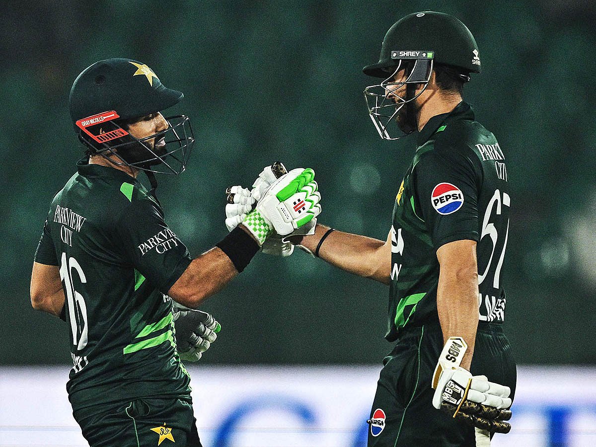 Pakistan's captain Mohammad Rizwan (left) celebrates with his teammate Salman Agha after scoring a half-century during the Tri-Nation series third one-day international (ODI) cricket match against South Africa at the National Stadium in Karachi on February 12.