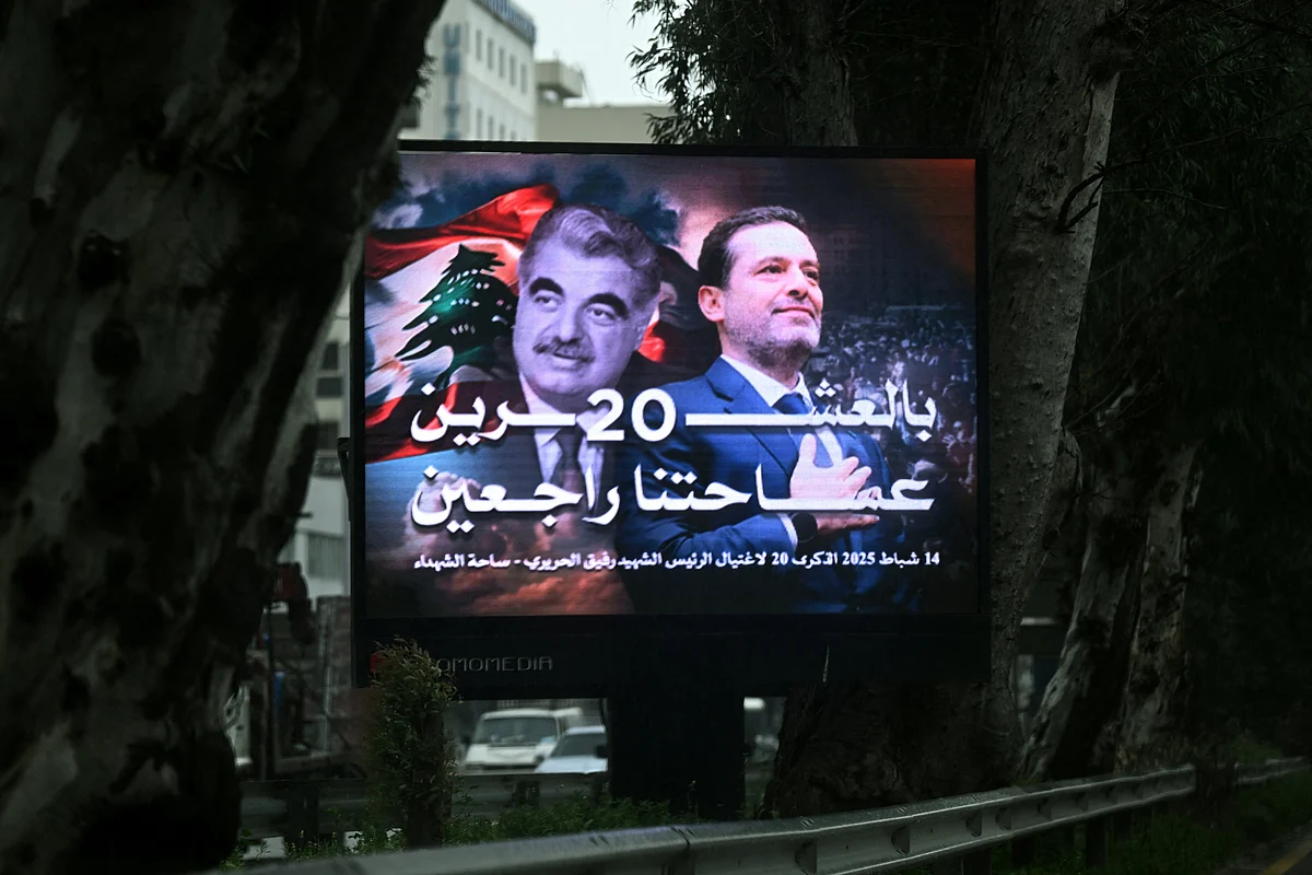 Traffic flows behind a giant billboard bearing a portrait of Lebanon's slain fromer premier Rafiq Hariri (L) and his son Saad Hariri, also a former prime minister, in central Beirut on February 13, 2025, on the eve of the 20th anniversary of Rafiq Hariri's assassination.
