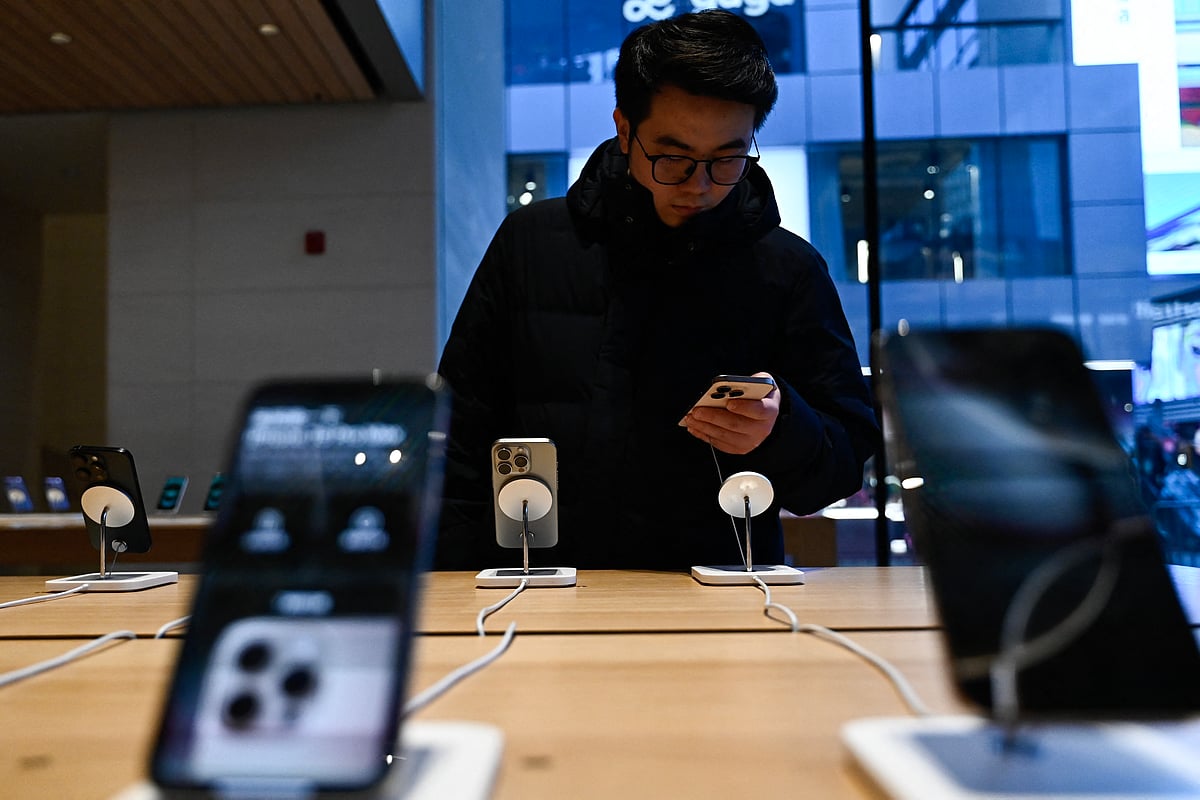 A man tests an iPhone in an Apple store in Beijing on February 13, 2025.
