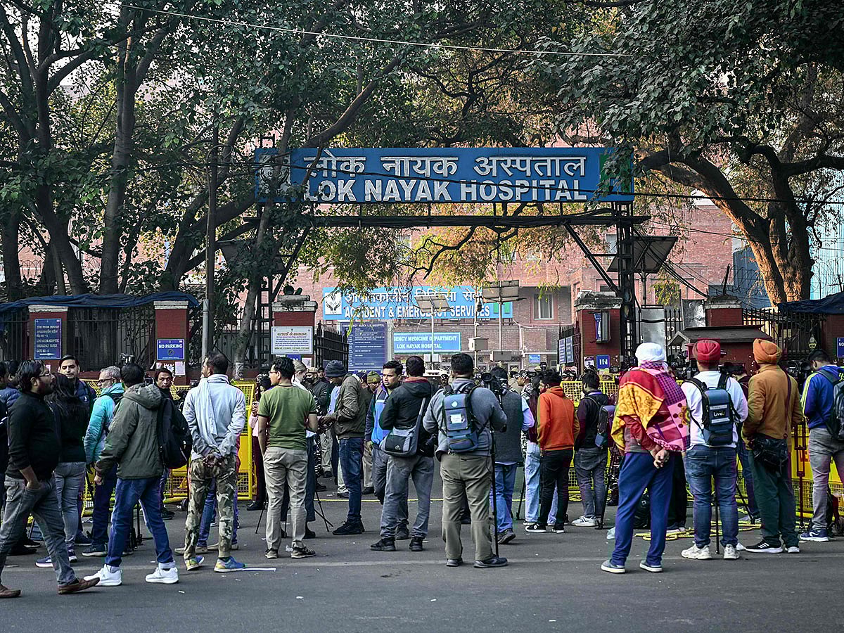 Media personnel stand outside a hospital where victims are brought following a stampede in New Delhi.