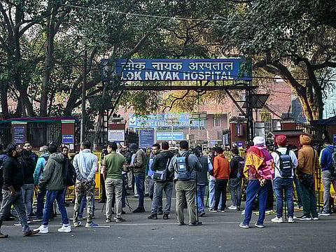 Media personnel stand outside a hospital where victims are brought following a stampede in New Delhi.