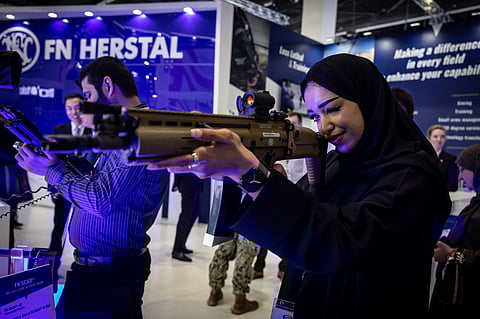 Visitors check weapons during the International Defence Exhibition Idex 2025, on February 17, 2025, in Abu Dhai.