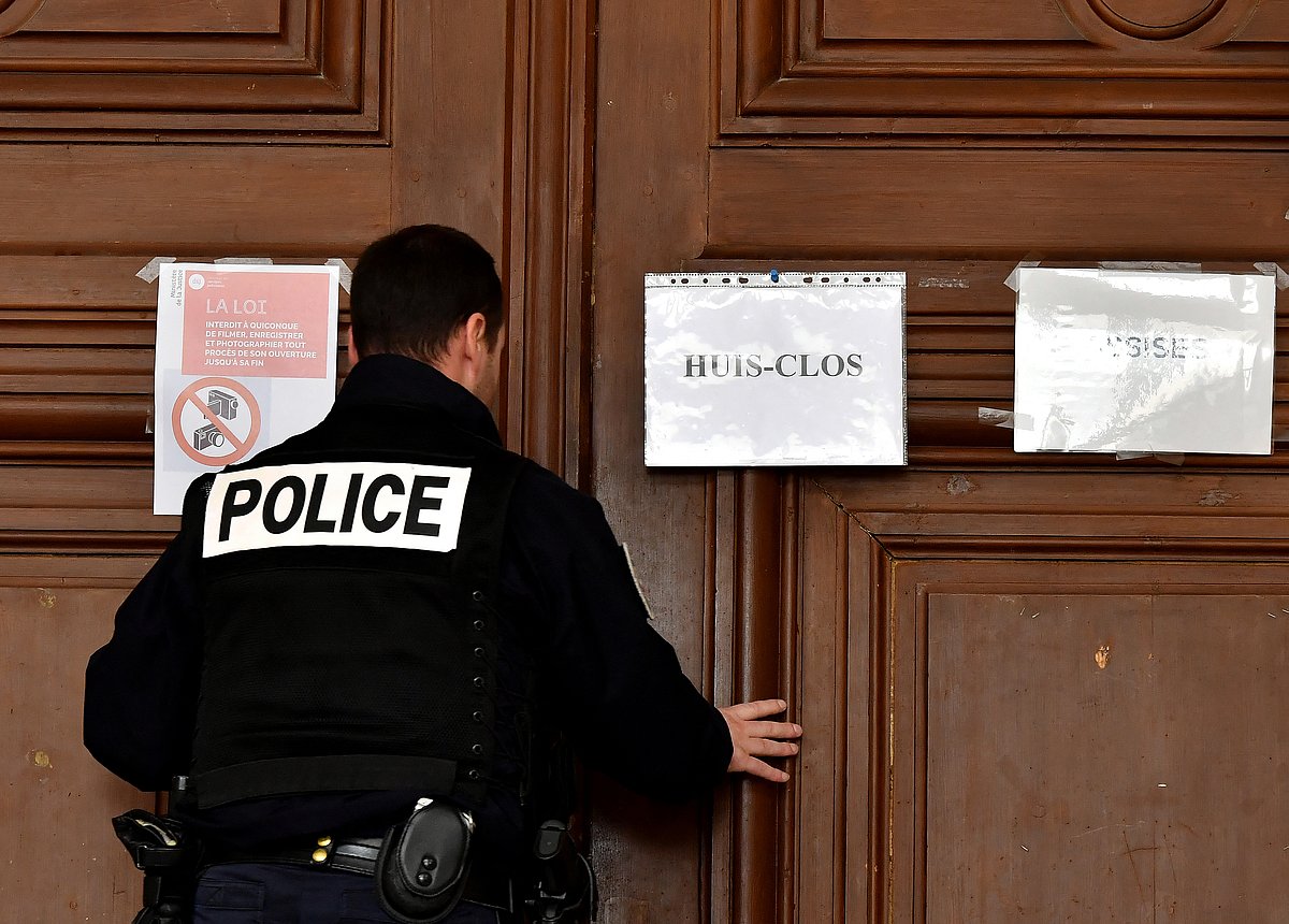 A policeman closes the door of the court room bearing the writing "Closed door" at the Assize courthouse in Saintes, western France, on March 13, 2020 during French surgeon Joel Le Scouarnec's trial for the alledged rape and sexual abuse of four children.
