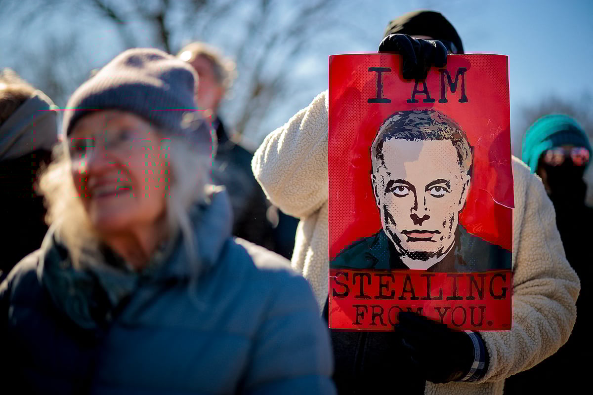 A sign depicting Tesla and SpaceX CEO Elon Musk is visible as protesters rally against the Trump administration during "Not My President's Day" protests at the Capitol Reflecting Pool on February 17, 2025 in Washington, DC. 