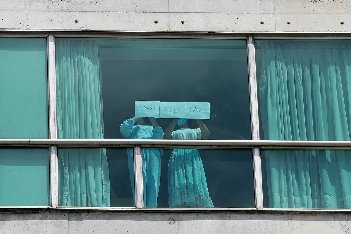 Migrants deported from the US place papers with a written message in the window of the Decapolis Hotel where they are temporarily staying in Panama City, February 18, 2024.