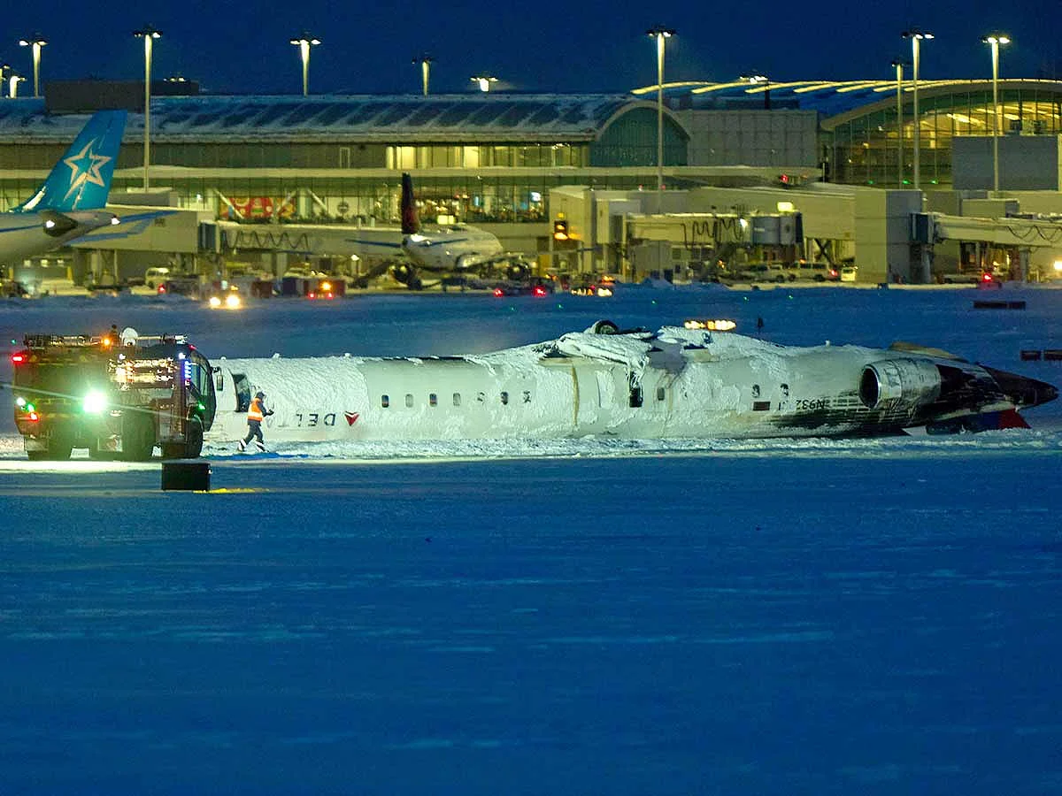 A Delta airlines plane sits on its roof after crashing upon landing at Toronto Pearson Airport in Toronto, Ontario, on February 17, 2025. 