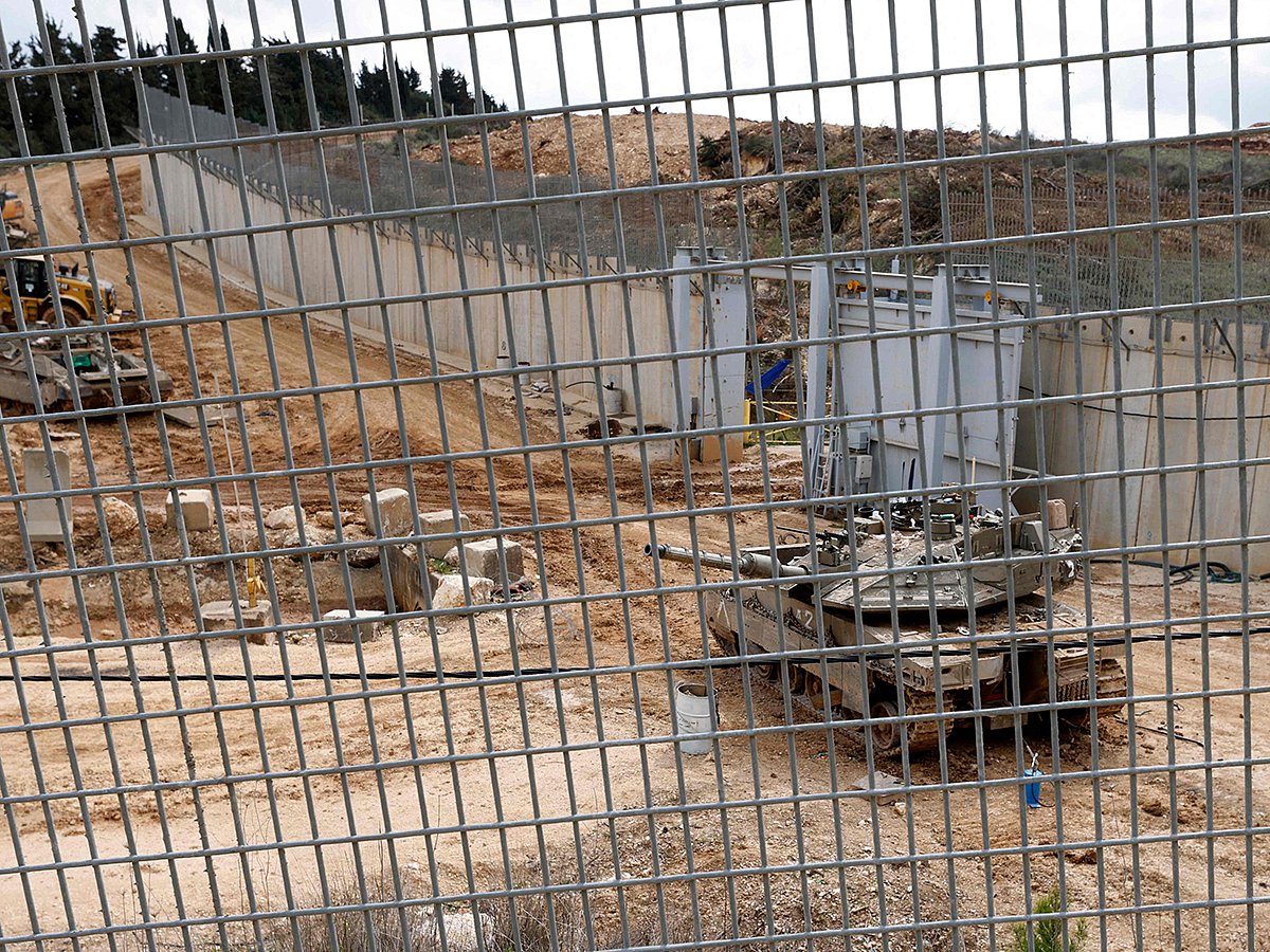 An Israeli army Merkava tank is deployed behind a concrete border wall at a position along Israel's northern border with Lebanon on February 19, 2025. 