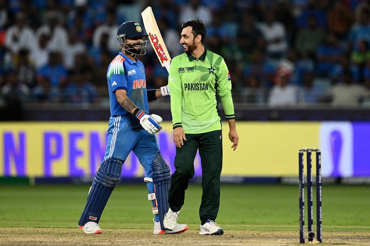 India's Virat Kohli (L) speaks with Pakistan's Salman Agha during the ICC Champions Trophy one-day international (ODI) cricket match between Pakistan and India at the Dubai International Stadium in Dubai on February 23, 2025.