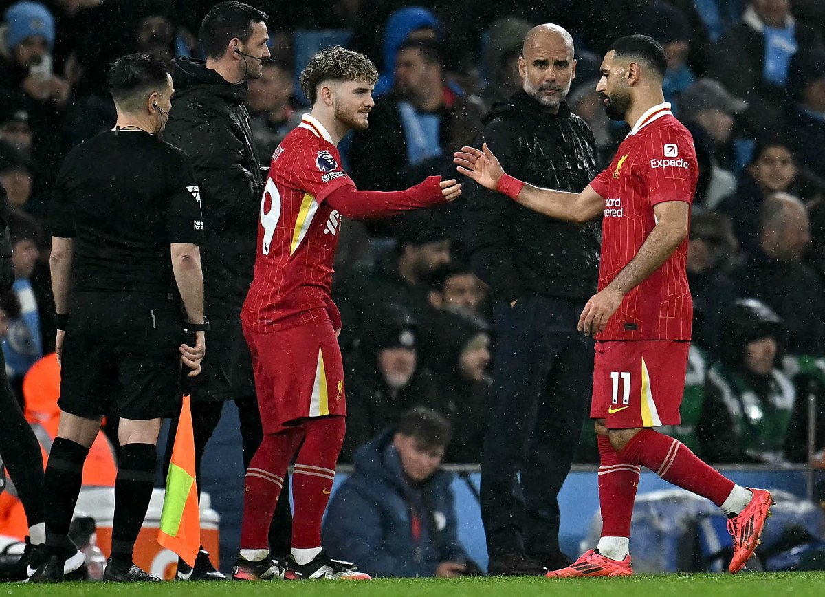 Manchester City's Spanish manager Pep Guardiola looks on as Liverpool's Egyptian striker Mohamed Salah (right) leaves the pitch after being substituted off for midfielder Harvey Elliott during the English Premier League football match at the Etihad Stadium in Manchester, north west England, on February 23.