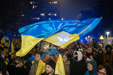 A boy waves a Ukrainian flag as Poles and members of the Ukrainian diaspora take part in demonstration in front of Polish Parliament in Warsaw to mark the 3rd anniversary of Russia's full scale war in Ukraine on February 24, 2025.