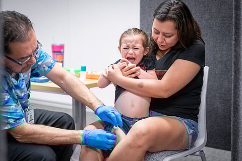 Priscilla Luna holds her 3 year-old daughter Avery Dahl, while she gets the MMR vaccine from Raynard Covarrubio at a vaccine clinic put on by Lubbock Public Health Department on March 1, 2025 in Lubbock, Texas.