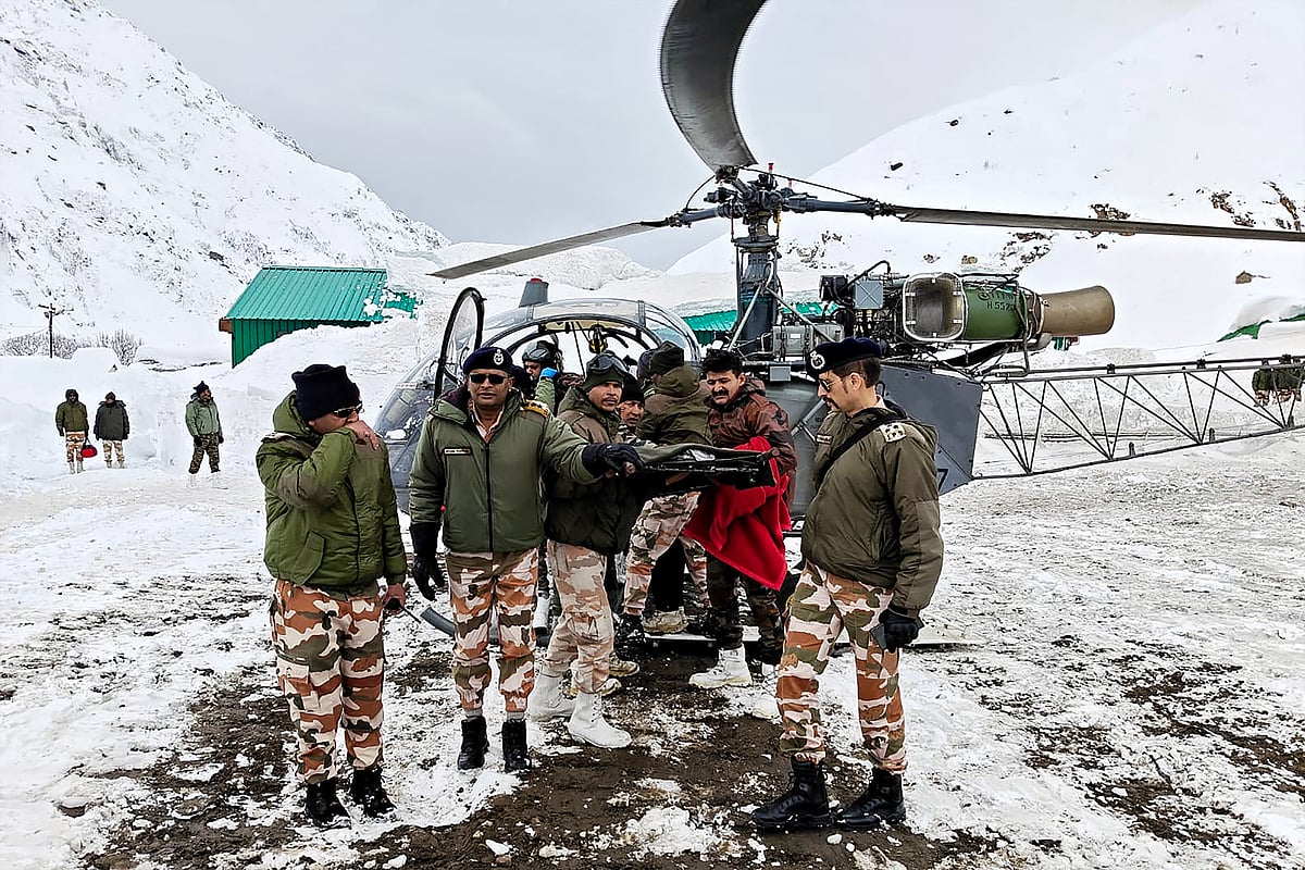 In this handout photograph taken on March 1, 2025 and released by the Department of Information and Public Relations (DIPR) Uttarakhand, security personnel carry a victim onto a helicopter during a rescue operation, a day after an avalanche hit a Border Roads Organisation (BRO) construction camp, as workers remain trapped under snow and debris near Mana village in the Chamoli district of India's Uttarakhand state.
