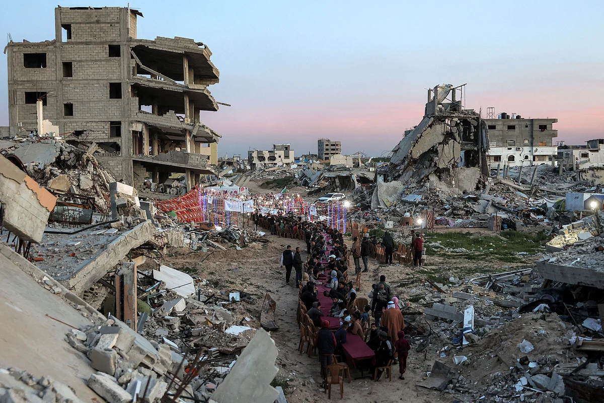 People gather by the rubble of destroyed buildings for a mass gathering for a communal iftar  meal on the second day of Ramadan in Al Dahduh in Gaza City's Tal Al Hawa district on March 2.