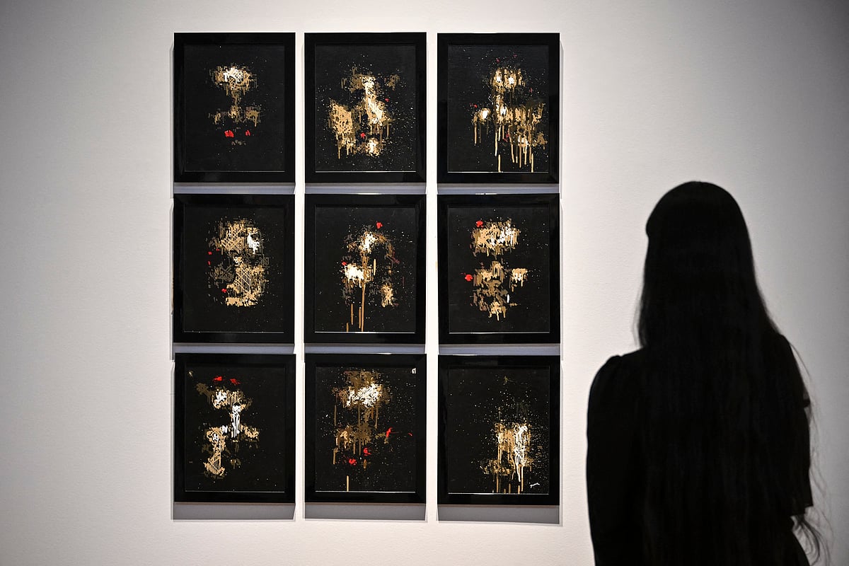 A person looks at AI artwork created by Pindar Van Arman’s Emerging Faces at a press preview for ‘Augmented Intelligence’ at Christie’s in New York City.