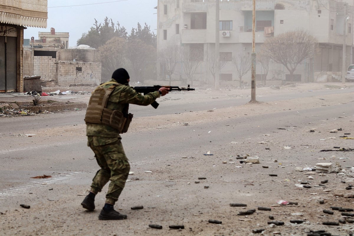 A member of Syria's security forces fires his weapon in Sanamayn, in the southern province of Daraa, during a reported large scale military campaign on March 5, 2025.