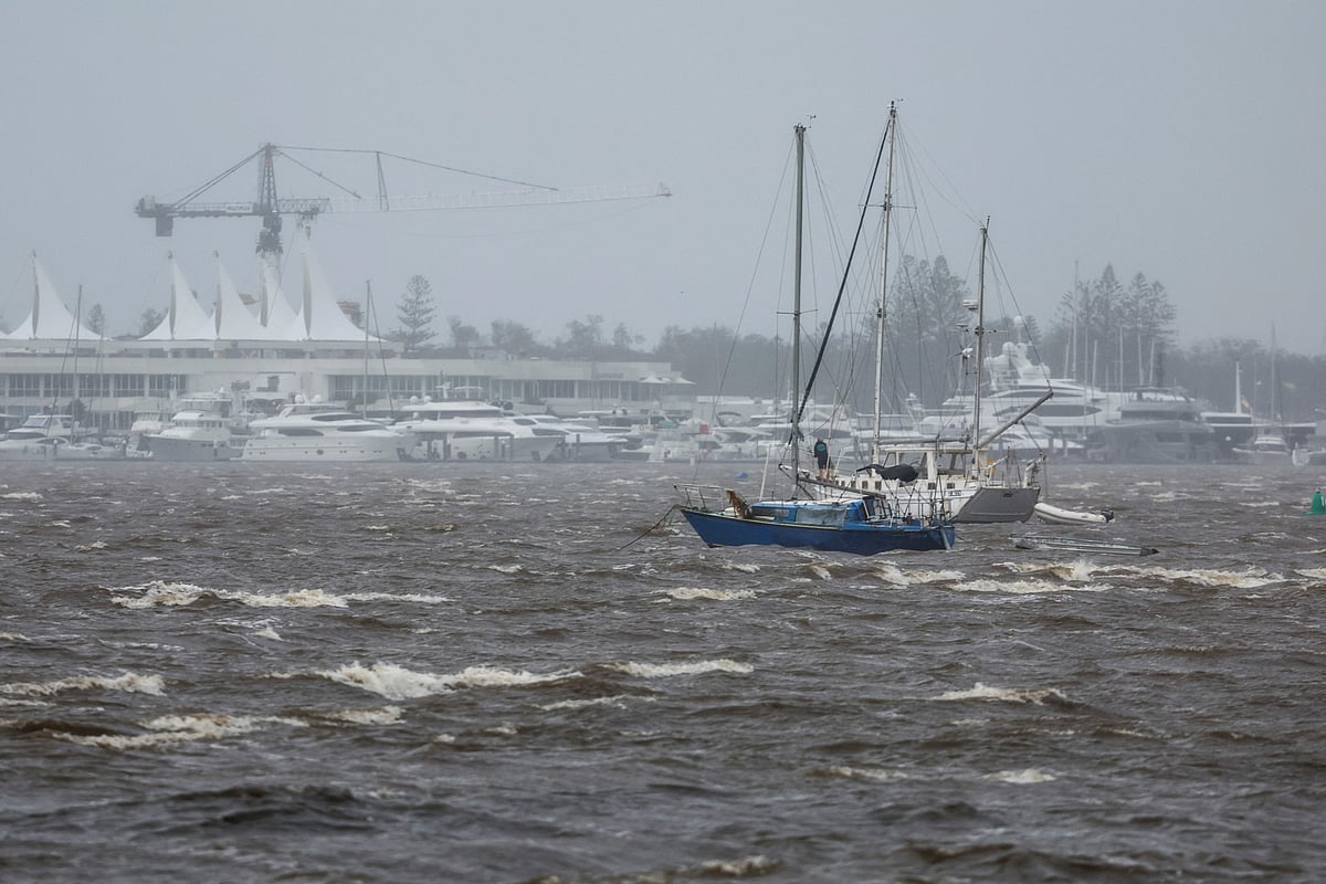 A man stands on a yacht as he prepares to move in high winds opposite the Mariner’s Cove Marina on the Gold Coast.