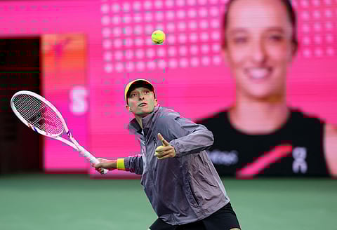 Iga Swiatek of Poland hits autographed balls into the crowd after her straight sets victory against Caroline Garcia of France in their second round match during the BNP Paribas Open at Indian Wells Tennis Garden.