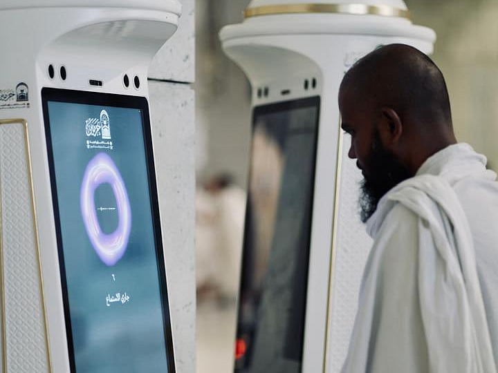 A worshipper approaches the Manara robot introduced in the Grand Mosque. 