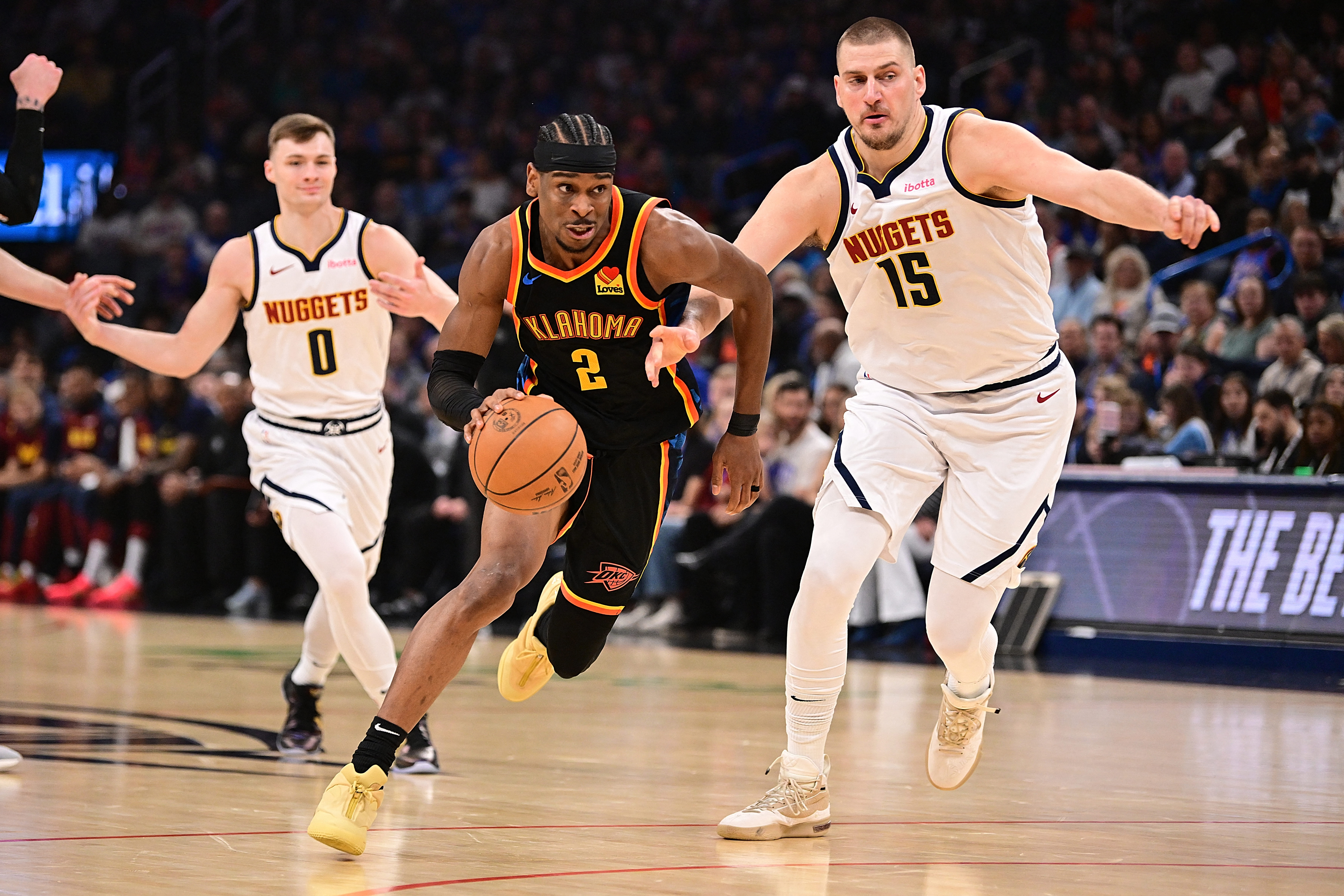 Shai Gilgeous-Alexander #2 of the Oklahoma City Thunder attempts to drive past Nikola Jokic #15 of the Denver Nuggets during the first half at Paycom Center on March 9, 2025 in Oklahoma City, Oklahoma.