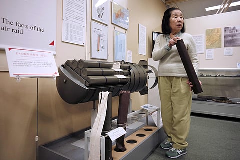 Shizuko Nishio, who will turn 86 on March 10, when Japan will commemorate 80 years after the bombing of Tokyo, shows a model of an incendiary bomb that was mainly used in the air raid on March 10, 1945, at The Center of the Tokyo Raids and War Damage in Tokyo. 