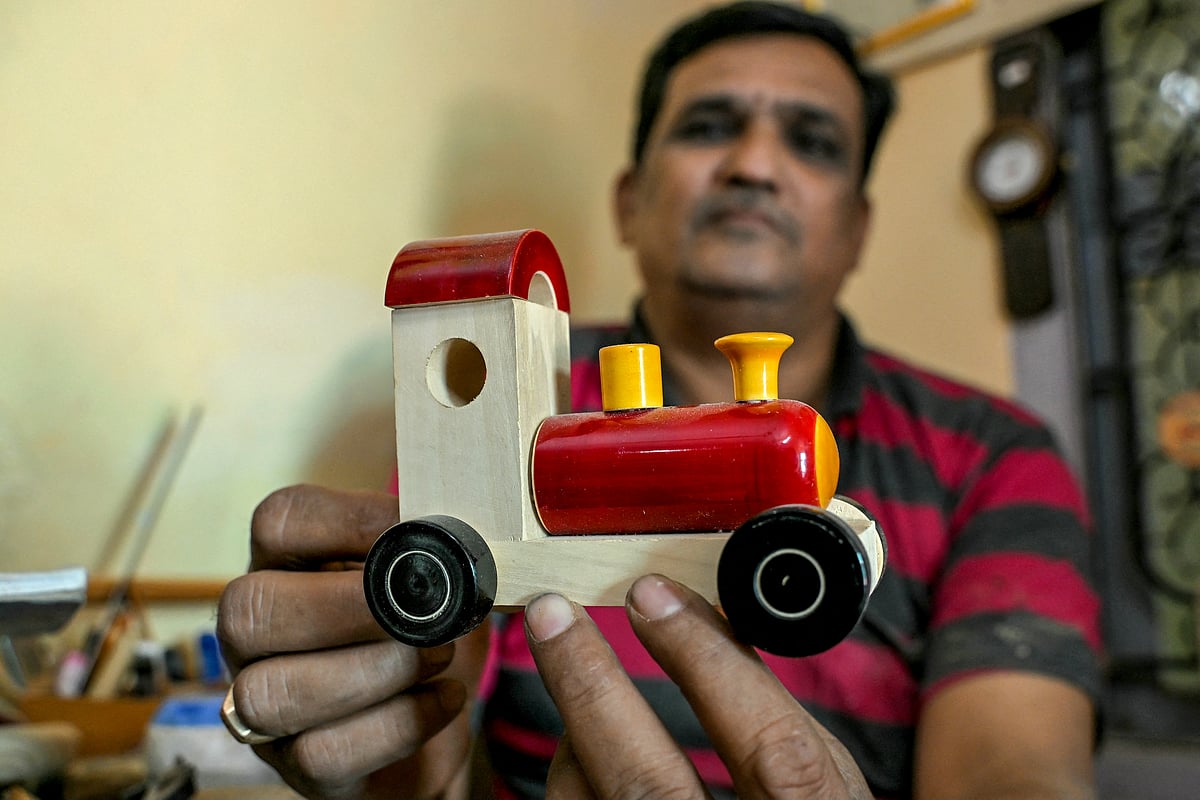 Artisan Kouser Pasha displaying a wooden toy train at his toy factory in Channapatna in the Ramanagara district of India's Karnataka state.