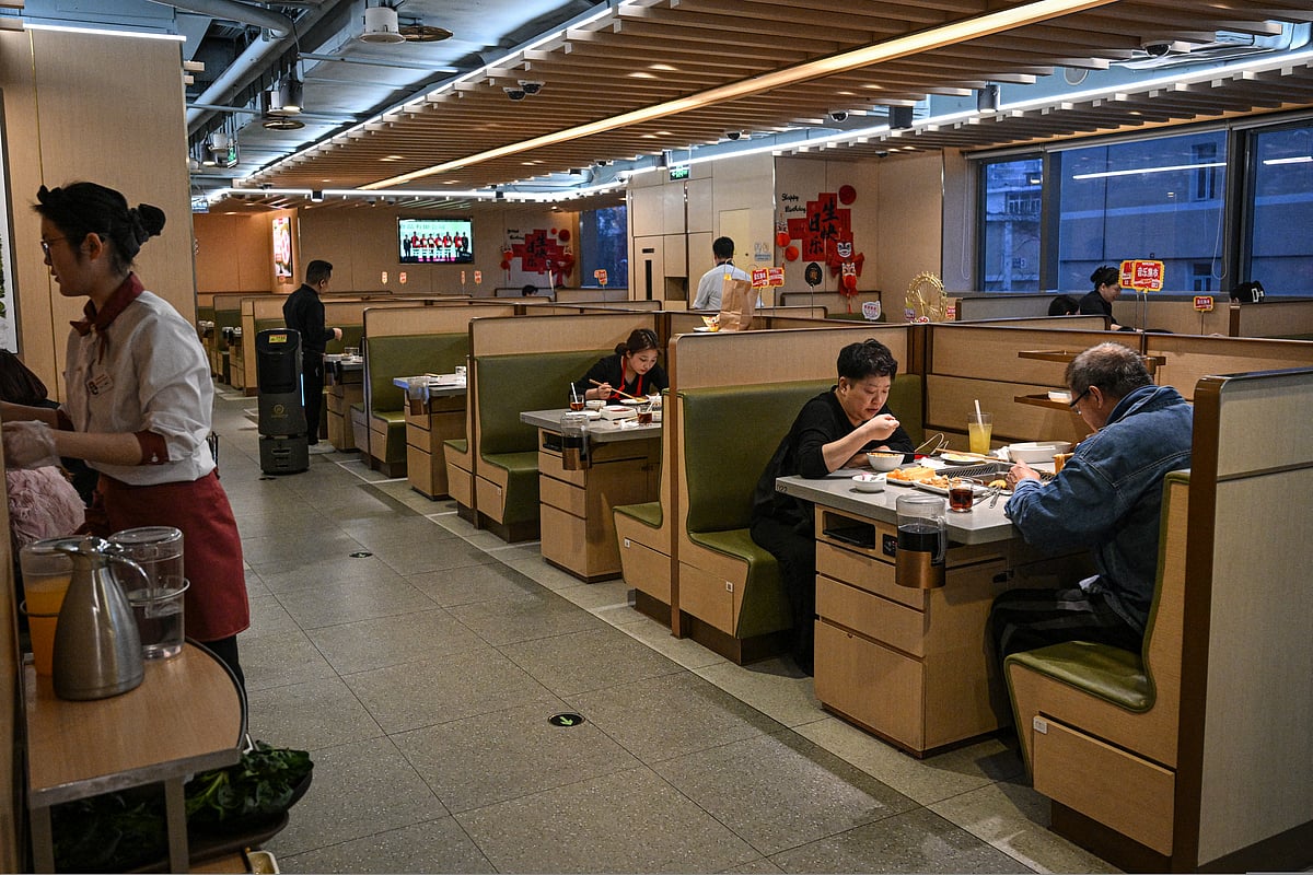People dine in a Haidilao hotpot restaurant in a shopping mall complex in Beijing on March 13, 2025.