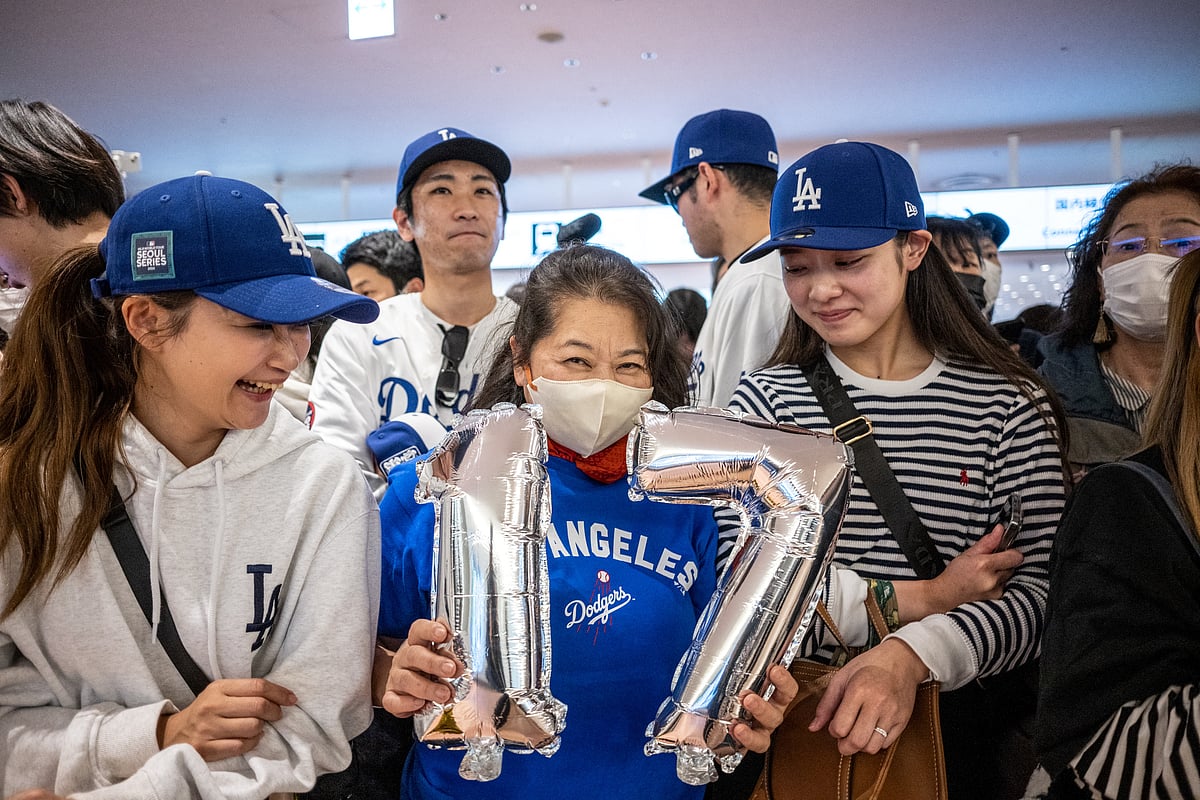 A supporter of the Los Angeles Dodgers' holding ballons of Shohei Ohtani #17 waits for the team to arrive at Tokyo’s Haneda airport on March 13, 2025.
