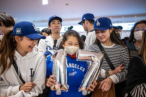 A supporter of the Los Angeles Dodgers' holding ballons of Shohei Ohtani #17 waits for the team to arrive at Tokyo’s Haneda airport on March 13, 2025.