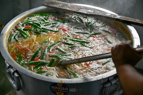 Bubur lambuk is traditionally prepared by volunteers in mosque courtyards.