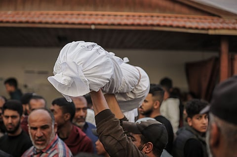 Mourners carry the body of a palestinian child killed during Israeli airstrikes at the Al Ahli hospital in Gaza City  on Tuesday, March 18, 2025.  