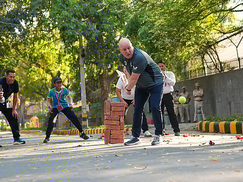 New Zealand Prime Minister Christopher Luxon playing cricket on the streets of New Delhi. 