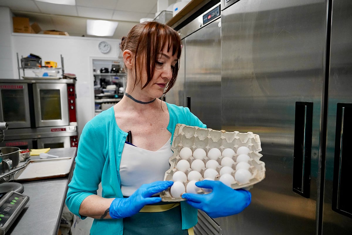 Annie Clemmons, owner of online bakery Chapman's DC, holds a carton of eggs in the ghost kitchen she uses for her business in Silver Spring, Maryland, on March 17, 2025.